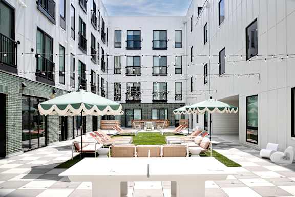 A white building with a green and white umbrella.