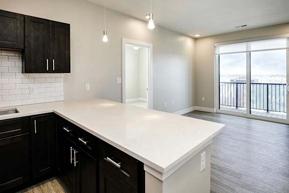 A kitchen with black cabinets and a white countertop.