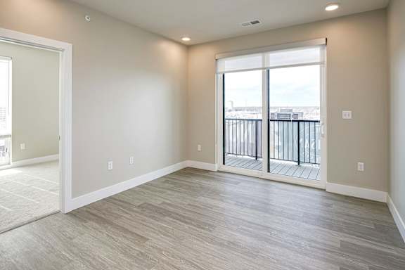 A spacious room with a view of a balcony.
