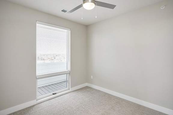 A room with a window and a fan.