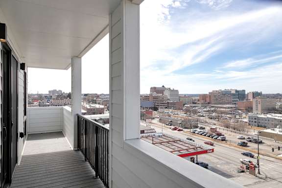 A balcony with a view of a city street and buildings.