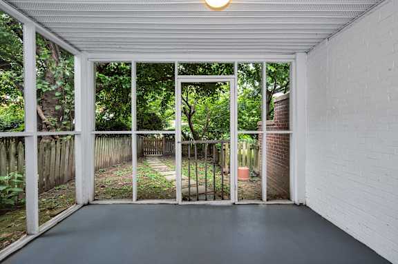 A white room with a glass door leading to a backyard.