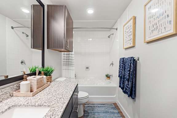 A bathroom with a white tub and a white sink.