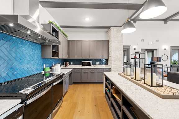 A modern kitchen with dark wood cabinets and a blue backsplash.