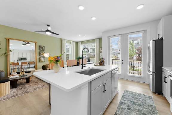 A modern kitchen with a large island and a view of the backyard.