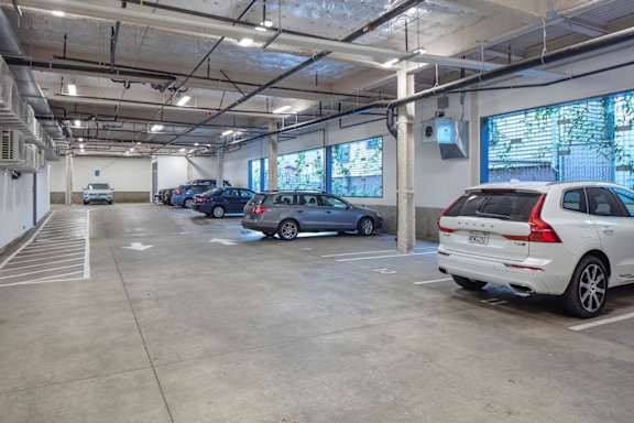 A parking garage with several cars parked inside.