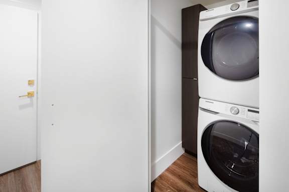 A white washing machine sits in a laundry room.