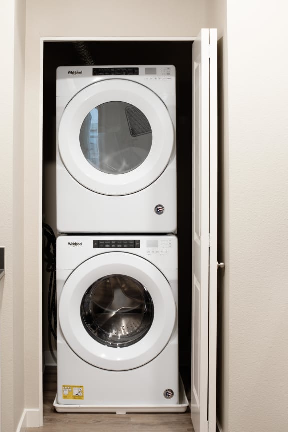 a washer and dryer sit in a closet next to a door