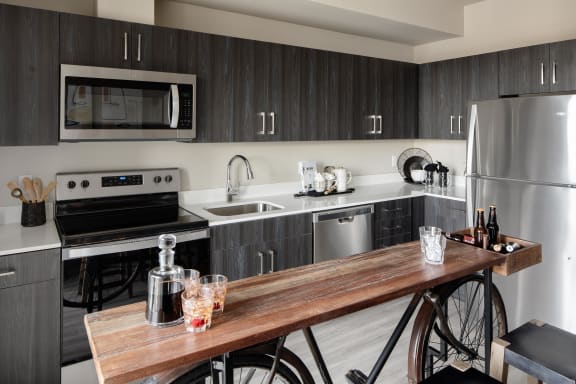 a kitchen with a wooden island and stainless steel appliances