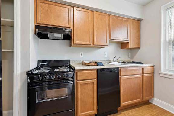 A kitchen with wooden cabinets and black appliances.