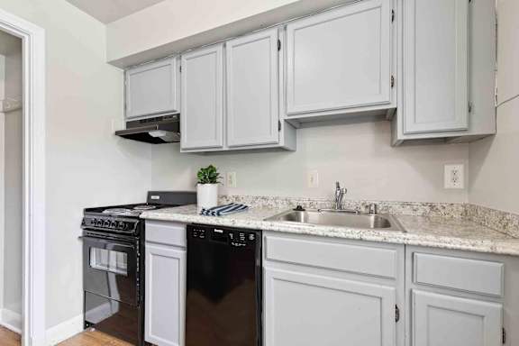 A kitchen with black appliances and white cabinets.