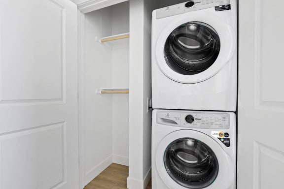 a white washer and dryer in a white laundry room