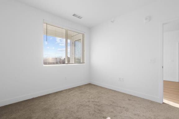 an empty room with a window and white walls