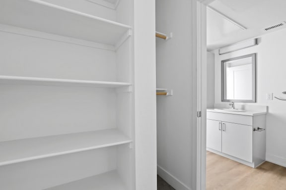 a bathroom with white cabinets and a white sink and a mirror