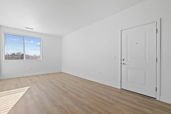an empty living room with white walls and wood flooring