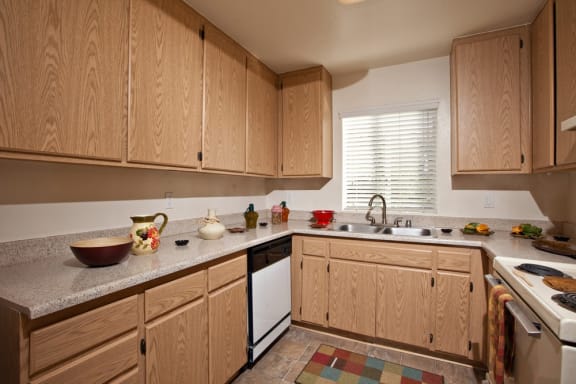 a kitchen with wooden cabinets and a white dishwasher