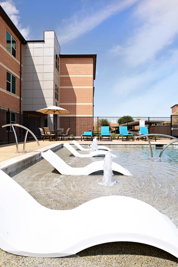 a swimming pool with a fountain in front of a building at The Liberty Lofts, Gainesville