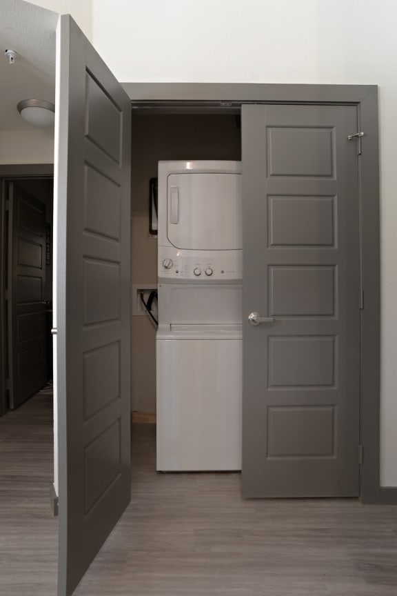 an open door to a kitchen with a refrigerator and a washing machine at The Liberty Lofts, Gainesville, TX