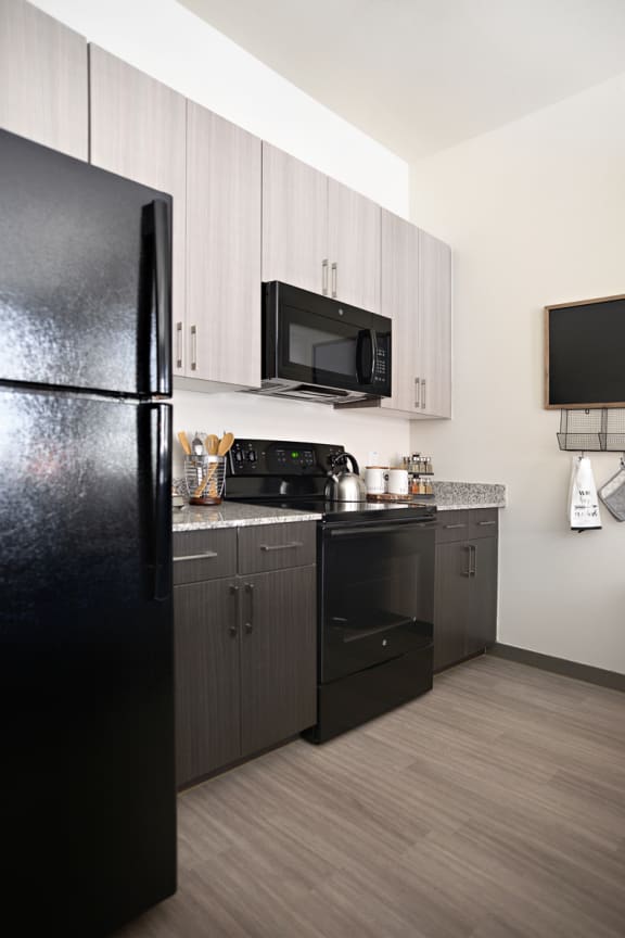 a kitchen with black appliances and a black refrigerator at The Liberty Lofts, Gainesville, 76240