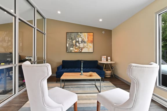 Living room with a blue couch and two white chairs