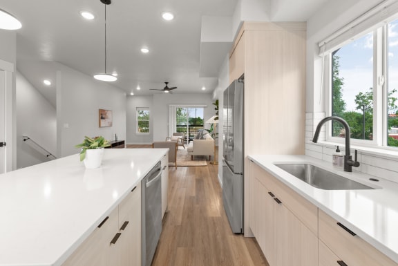 a white kitchen with white counter tops and a stainless steel refrigerator&#xA0;at Alpine Landing Townhomes, Garden City, ID