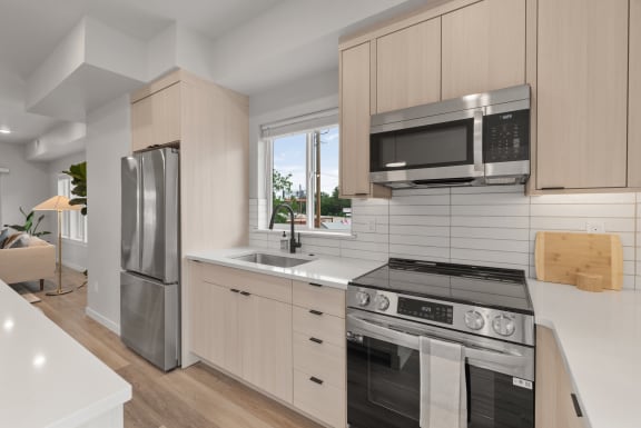 a modern kitchen with white cabinets and stainless steel appliances&#xA0;at Alpine Landing Townhomes, Garden City, Idaho
