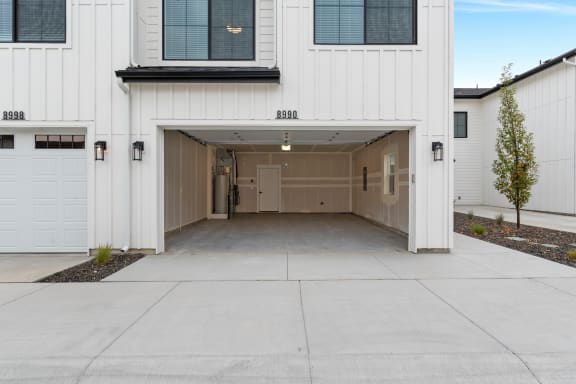 the front of a white house with a garage door open&#xA0;at Alpine Landing Townhomes, Garden City