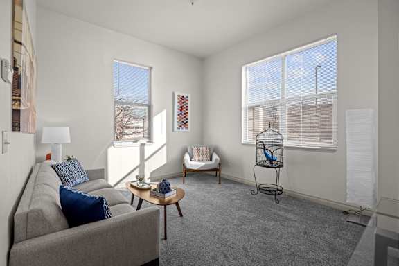 A living room with a grey couch, a coffee table, and a chair.