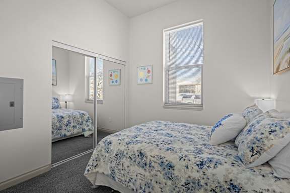 A bedroom with a large bed and a mirror on the wall.