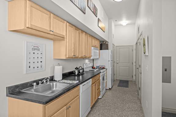 A kitchen with wooden cabinets and a black countertop.