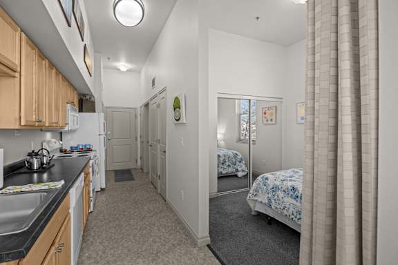 A kitchen with a sink, stove, and refrigerator.
