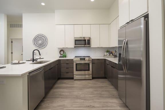 a kitchen with stainless steel appliances and white counter tops