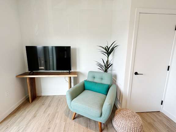 Living room with comfortable chair and TV at Cannery Flats, Bozeman, MT