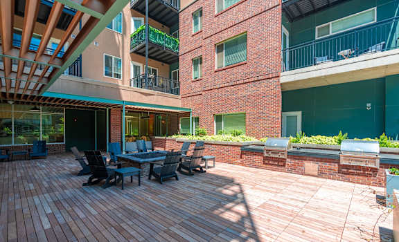 a large patio with a table and chairs outside of an apartment building at Sylvan Uptown, Colorado, 80203