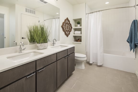 a bathroom with two sinks and a shower and a toilet