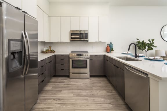 a modern kitchen with stainless steel appliances and white cabinets