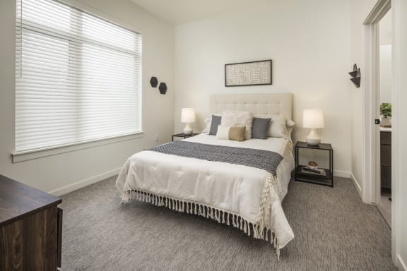 a bedroom with a bed and a large window