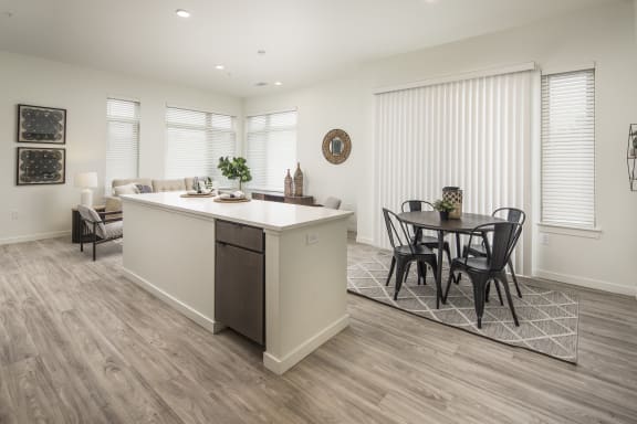 an open kitchen and living room with a dining room table and chairs