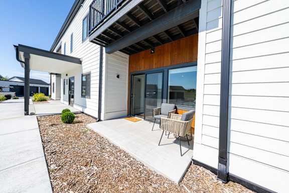 A modern house with a white exterior and a wooden door.