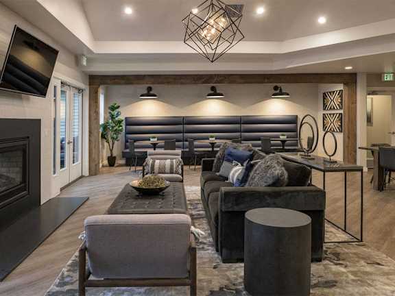 Clubhouse lounge with sectional seating and geometric chandelier at Edgewater Apartments, Boise, 83703