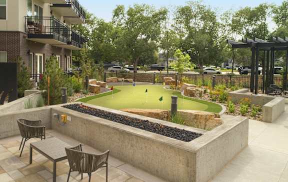 a courtyard with a miniature golf course and tables and chairs at Cycle Apartments, Fort Collins, 80525