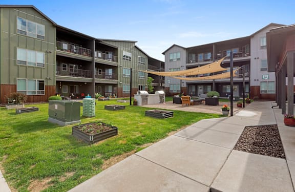 Apartment complex with green grass and trees.