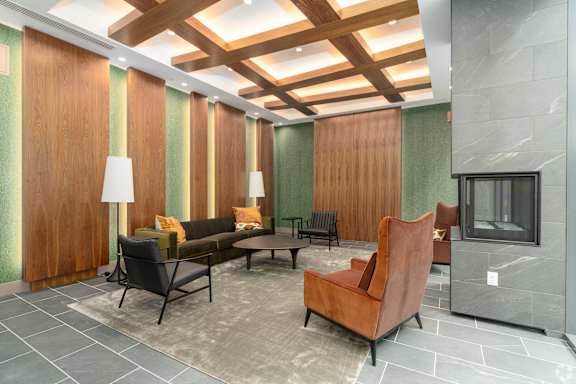 A living room with a brown chair and a grey sofa  at 605 Concord at Fresh Pond Apartments, Massachusetts
