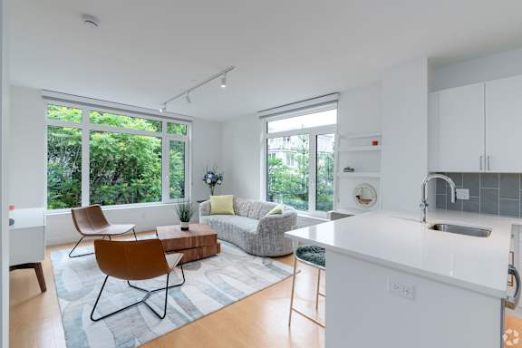 A modern kitchen with white cabinets and a white island. at 605 Concord at Fresh Pond, Cambridge, MA