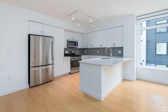A kitchen with a refrigerator, oven, and microwave. at 605 Concord at Fresh Pond, Cambridge, 02138