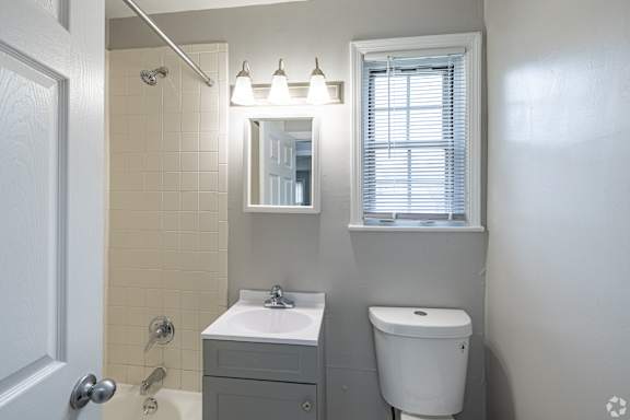 A bathroom with a sink, mirror, and toilet.