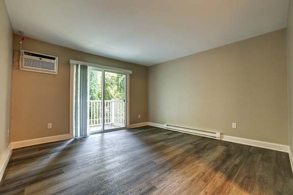 A room with a sliding glass door leading to a balcony.