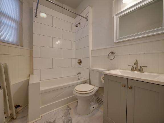 A white bathroom with a toilet, sink, and bathtub.