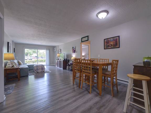 A dining room with a wooden table and chairs.
