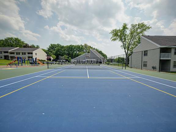 A blue tennis court with white lines and a yellow border.